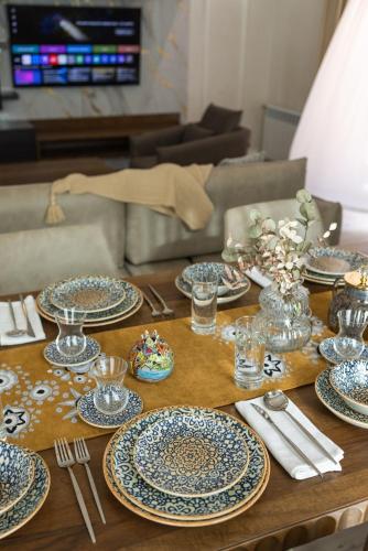 a wooden table with blue and white plates and silverware at Spacious and Premium 2 Bedroom Apartment with Panoramic Terrace and Rudaki Park View in Prime Dushanbe Location in Dushanbe