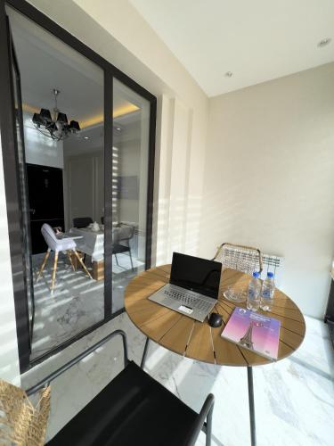 a laptop computer sitting on a wooden table in a room at Spacious and Premium 2 Bedroom Apartment with Panoramic Terrace and Rudaki Park View in Prime Dushanbe Location in Dushanbe