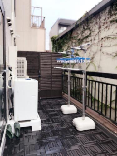a balcony with a heater and an umbrella on a fence at Dain Hostel1 in Tokyo
