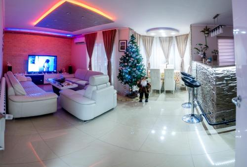 a living room with a christmas tree and white furniture at Apartmani Đorđević in Soko Banja
