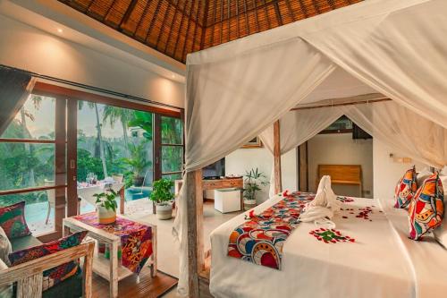 a bedroom with a large bed with a canopy at Anusara Luxury Villas in Ubud