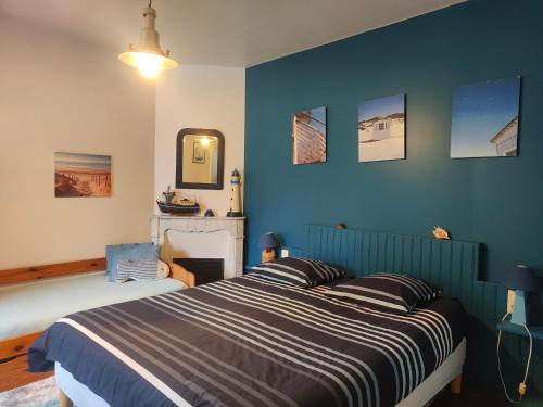 ein Schlafzimmer mit einem Bett mit blauen Wänden in der Unterkunft Les Volets Bleus in Pornic