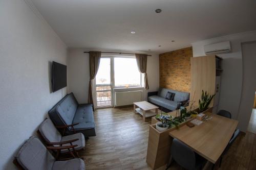 a living room with a couch and a table at Apartmán u Kulíška in Prievidza