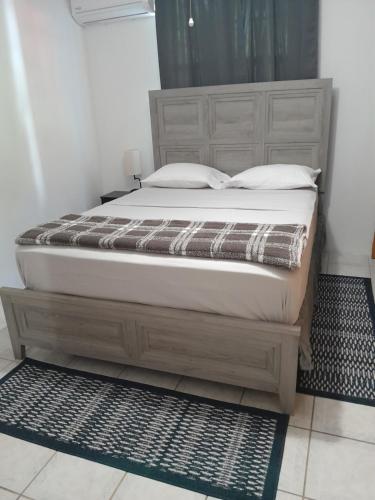 a bed in a bedroom with a wooden bed frame at Abigail Diamond 2 bedroom apt Near Nanny Cay marina in Hannah