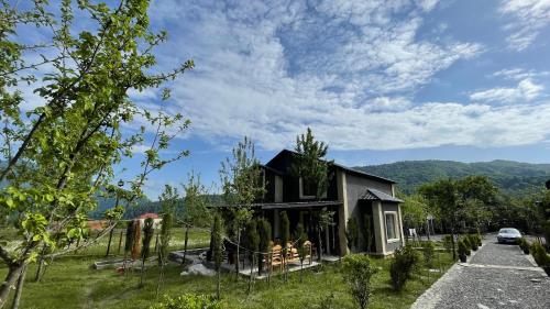 a house with people sitting outside of it at Sweet house Qalaciq in İsmayıllı