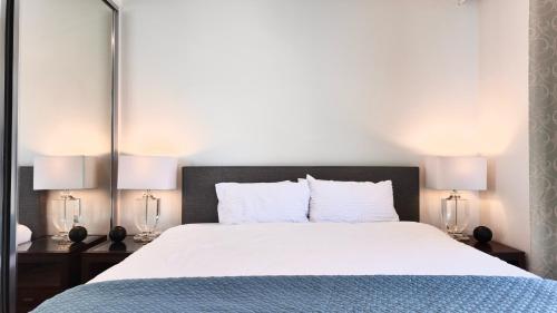 een slaapkamer met een groot wit bed met twee lampen bij Premium Twin King Ensuite plus Double sofa bed - Mcity shopping center - Clayton - Monash University and Hospitals - Super Fast Wifi - Free Parking & Amenities - Complementary drinks & coffee in Clayton North