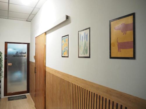 a hallway with a door and three pictures on the wall at Bed Space Hostel Khaosan in Bangkok