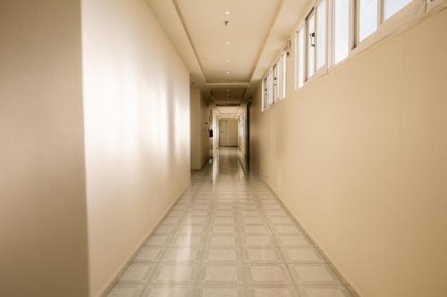 an empty hallway with white walls and a tile floor at فندق الردهة in Al Ḩawīyah