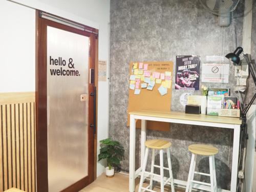a table and stools in a room with a counter at Bed Space Hostel Khaosan in Bangkok