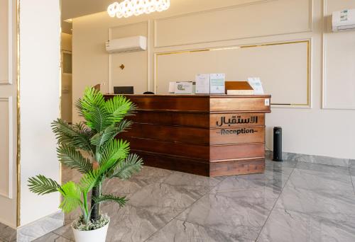 a reception desk in a lobby with a palm tree at فندق الردهة in Al Ḩawīyah