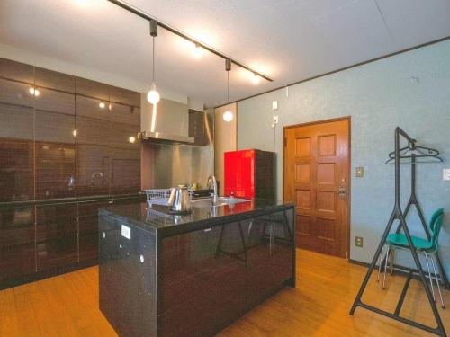 a kitchen with a counter and a red refrigerator at SUMITSUGU HOUSE Grandpa in Kumamoto