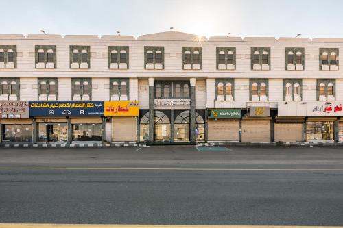 a large white building with windows and a street at فندق الردهة in Al Ḩawīyah