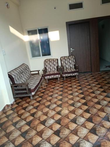 two chairs sitting in a room with a checkered floor at Luxe Shree Krishna Kunj Villa in Ujjain