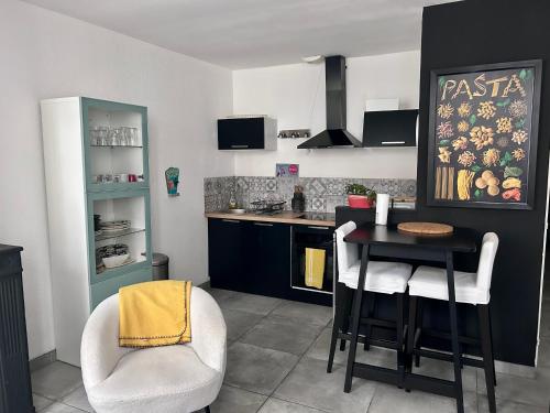 une cuisine avec une table et des chaises dans une cuisine dans l'établissement Appartement cosy avec balcon, centre historique, à Bordeaux