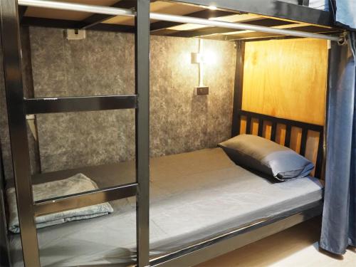 a bunk bed in a room with a cross on the wall at Bed Space Hostel Khaosan in Bangkok