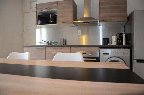 une cuisine avec une table et des chaises blanches dans l'établissement Large apartment 85 m2 Chambéry center, à Chambéry