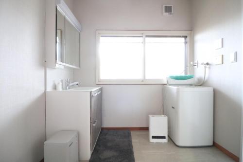 a bathroom with a sink and a refrigerator and a window at デコピンハウス in Hanamaki