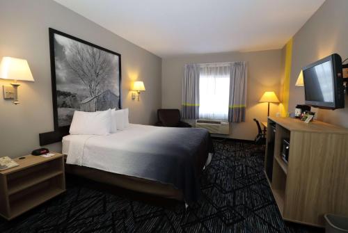a hotel room with a bed and a flat screen tv at Super 8 by Wyndham Perryville in Perryville