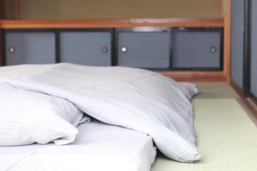 a pile of white pillows sitting on top of a bed at デコピンハウス in Hanamaki