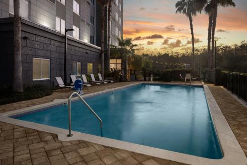 a large blue swimming pool in a building at Courtyard by Marriott Orlando South/Grande Lakes Area in Orlando