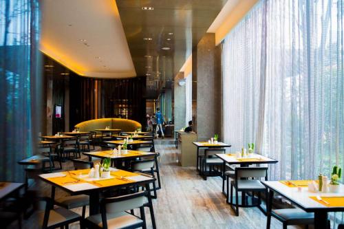 a dining room with tables and chairs in a restaurant at Wyndham JinJiang Hotel in Jinjiang
