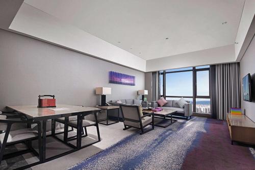 a living room with a table and chairs and a couch at Wyndham JinJiang Hotel in Jinjiang