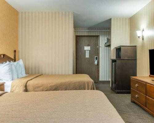a hotel room with two beds and a television at Quality Inn Gaylord in Gaylord