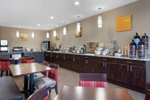 a restaurant with wooden tables and a counter with at Comfort Suites Terre Haute University Area in Terre Haute
