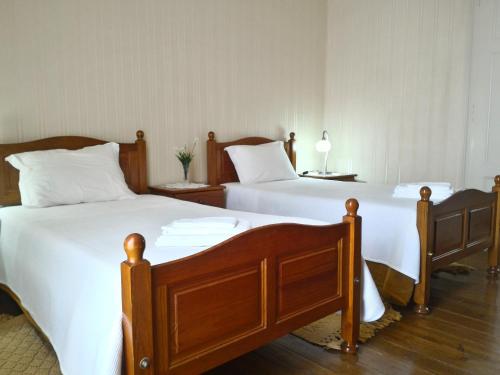 Cette chambre comprend 2 lits avec des draps et des oreillers blancs. dans l'établissement Apartment Rua Corpo de Deus in Coimbra, à Coimbra