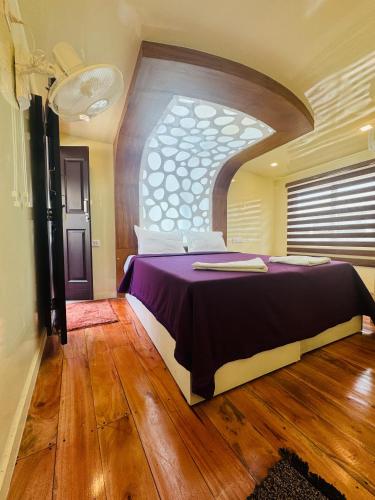 a bedroom with a large bed with a large window at Dreams Spectrum Luxury houseboat in Alleppey