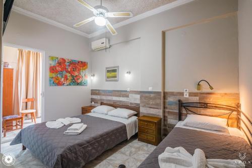 a bedroom with two beds and a ceiling fan at Bikakis Family Apartments in Kissamos