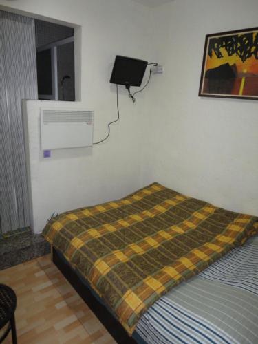 a bedroom with a bed with a blanket on the wall at Central Station Hostel Barcelona in Barcelona