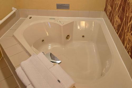 a white bath tub with towels in a bathroom at Country Inn & Suites by Radisson, Convention Center in Altoona