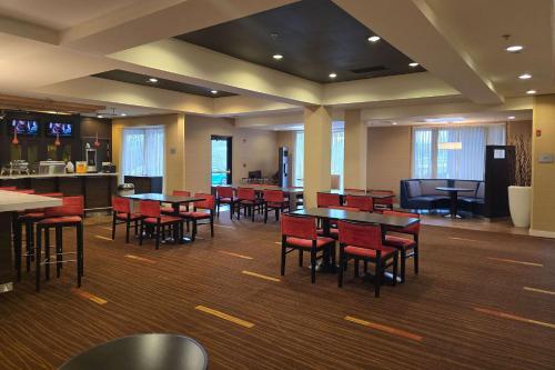 a restaurant with tables and chairs and a kitchen at Country Inn & Suites by Radisson, Convention Center in Altoona