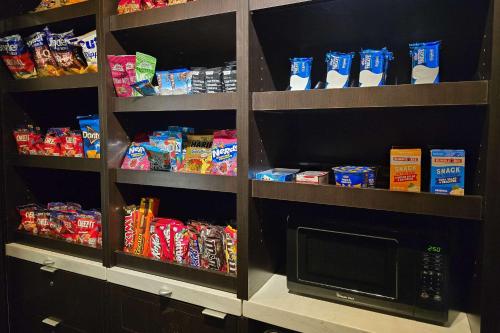 a kitchen pantry with a microwave and some food at Country Inn & Suites by Radisson, Convention Center in Altoona