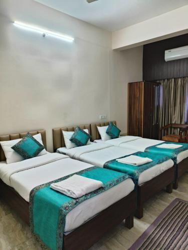 two beds in a room with green and white at NANDI RETREAT HomeStay in Varanasi