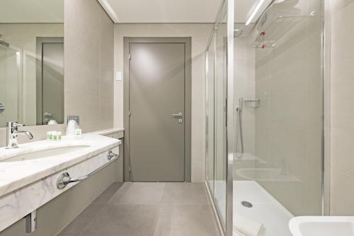 a bathroom with a shower and a sink at Just Hotel Saronno in Saronno
