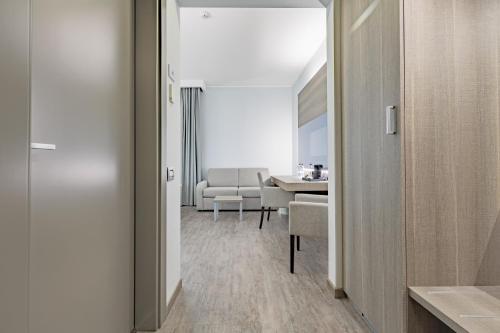 a hallway with a room with a table and chairs at Just Hotel Saronno in Saronno