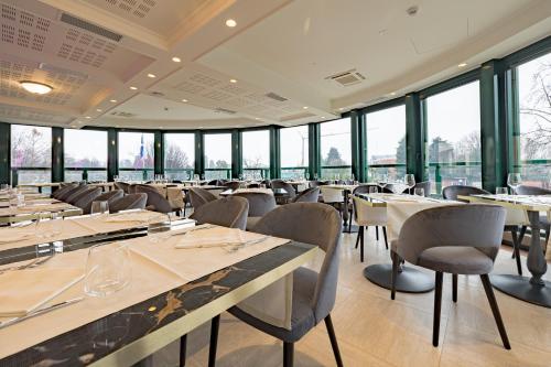 a restaurant with tables and chairs and windows at Just Hotel Saronno in Saronno