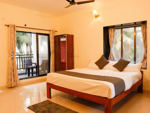 a bedroom with a large bed and a balcony at The Brisa Nature Stay in Revadanda