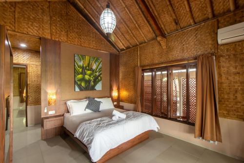 a bedroom with a bed and a painting on the wall at Family Only Pool & Mountain View Modern Bamboo Villa - De Reiz Ethnic Syariah in Bandung