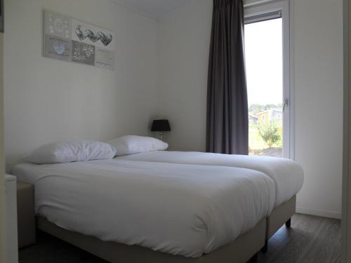 a large bed in a bedroom with a window at Stylish Villa in Bemelen in Bemelen