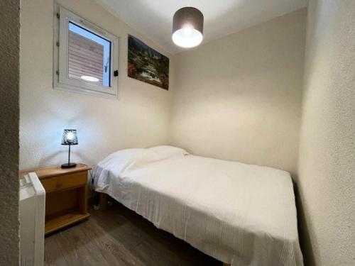une petite chambre avec un lit blanc et une fenêtre dans l'établissement Résidence Hameau Thermes Ii - HAMEAU DES THERMES 4 personnes à deux pas des Thermes et Télécabine MAE-4541, à Saint-Lary-Soulan