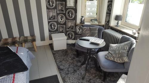 a living room with a table and chairs and a radiator at B&B Le Bonimenteur in Charleroi