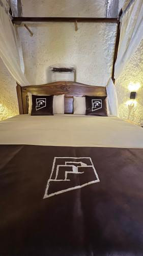 a bedroom with a bed with a wooden head board at the suwgra-Al-Jabal Al-Akdar in Sūkirah