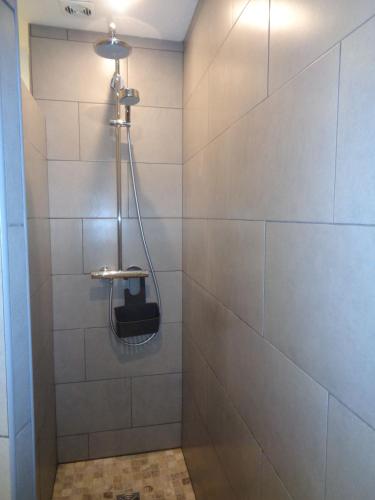 une douche dans une salle de bain avec un mur carrelé dans l'établissement Croisette-Oasis, à Cannes