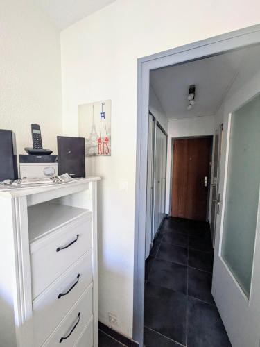 Cette chambre dispose d'une commode blanche et d'un couloir. dans l'établissement Studio Central 2 pers proche Geneva, à Saint-Julien-en-Genevois