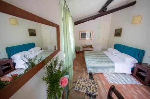 a room with three beds and a mirror at Agriturismo La Montagnola in Torgiano