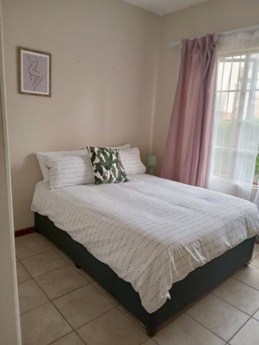 a bed in a bedroom with a window at ReMo in Sandton