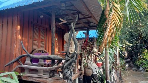a wooden house with a chair in front of it at Kakrona Pouk Homestay in Siem Reap